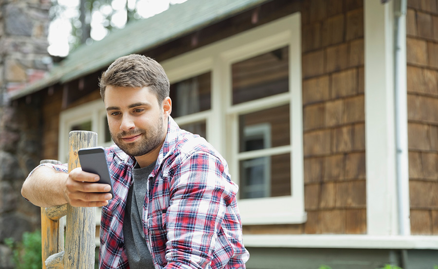 Man using mobile in front of short term rental