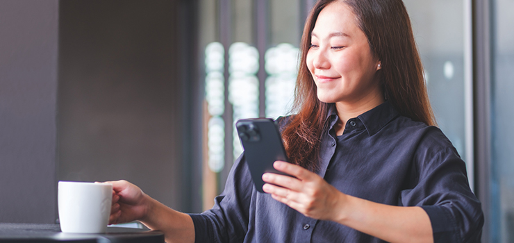 Woman using mobile phone at cafe