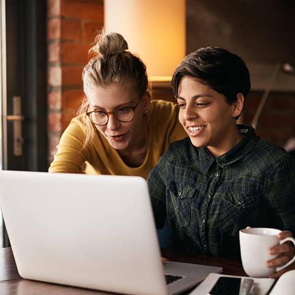 Two women working on a computer 