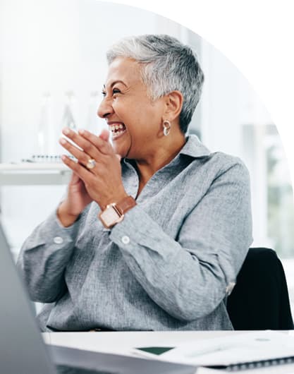 Woman smiling and clapping at desk