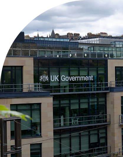 UK Government office building with modern glass facade overlooking a cityscape, representing public sector administration and services.
