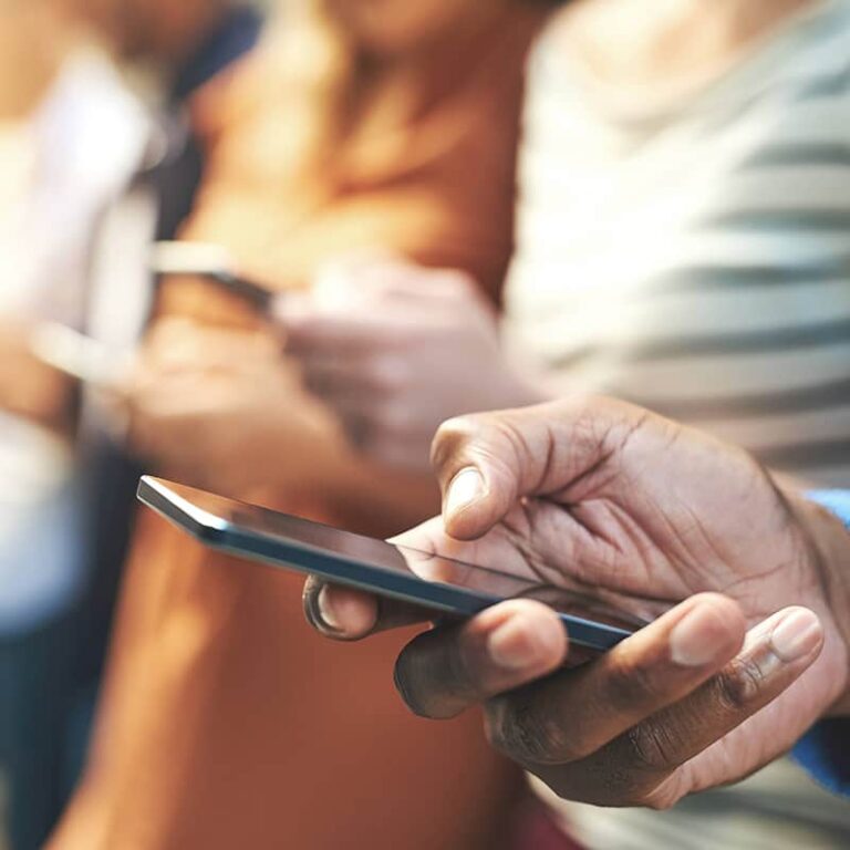 Close up of a man holding a phone in one hand