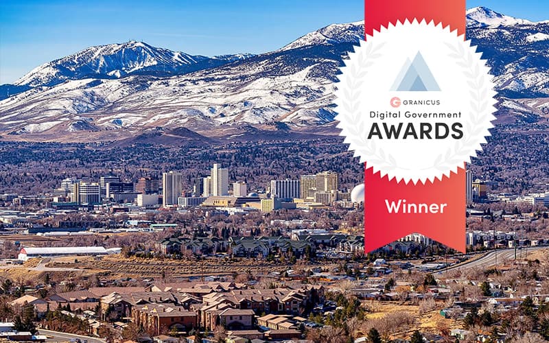 City skyline of Reno, Nevada with snow-covered mountains in the background and an award badge overlay indicating recognition for digital government excellence.