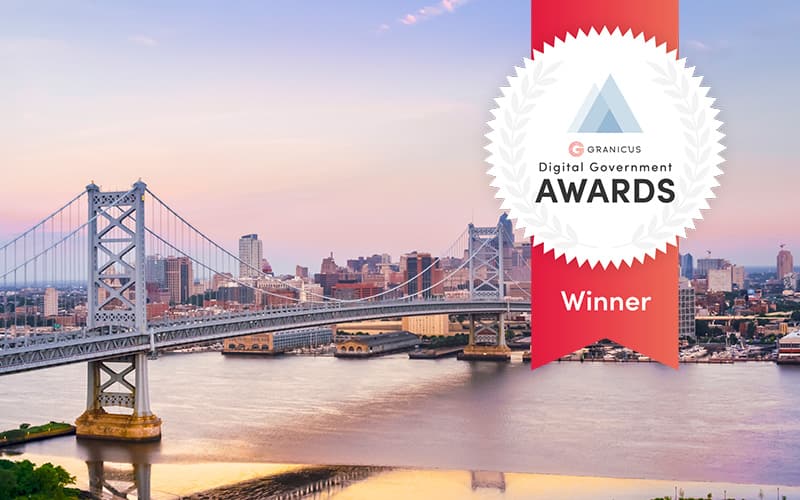 Benjamin Franklin Bridge over the Delaware River at sunset, with Philadelphia skyline and a Digital Government Awards Winner badge overlay.