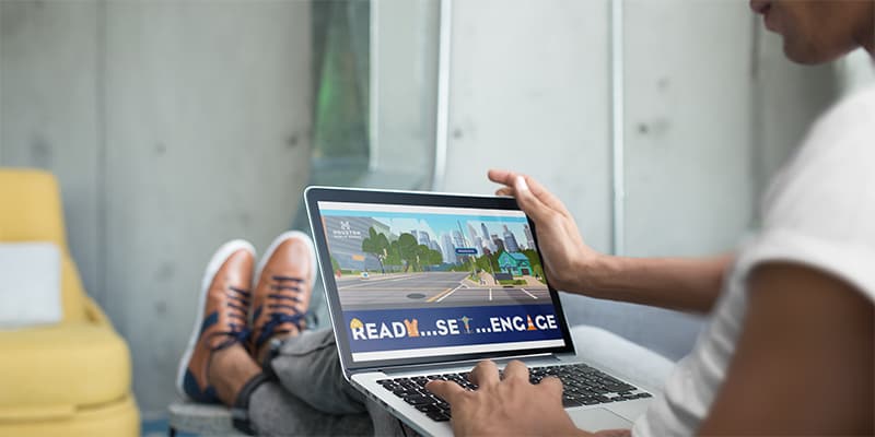 A woman sitting down while viewing the Engage Houston splash page.