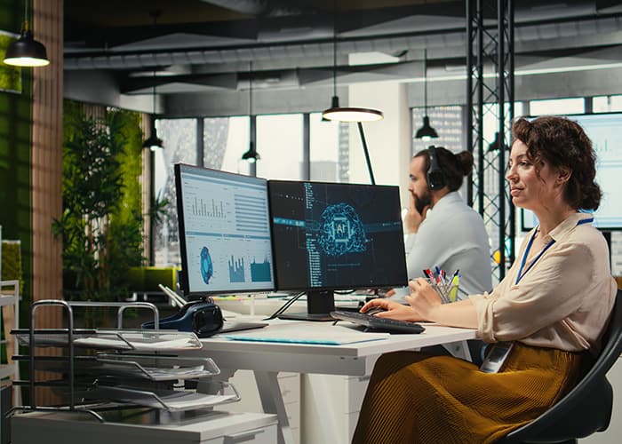 Woman in the office, using a computer checking reports with AI