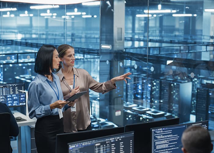 AI specialists analyzing algorithm performance on a tablet in a modern data center.