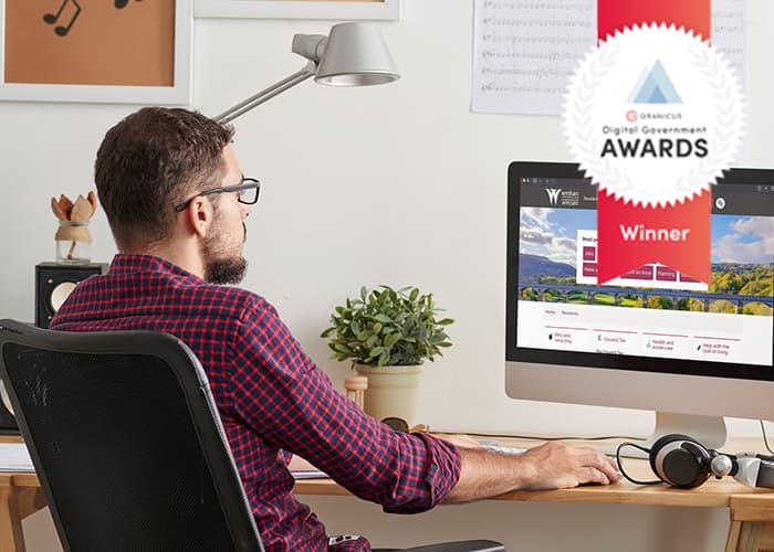 A person in an office using a computer and viewing the Wrexham County webpage.