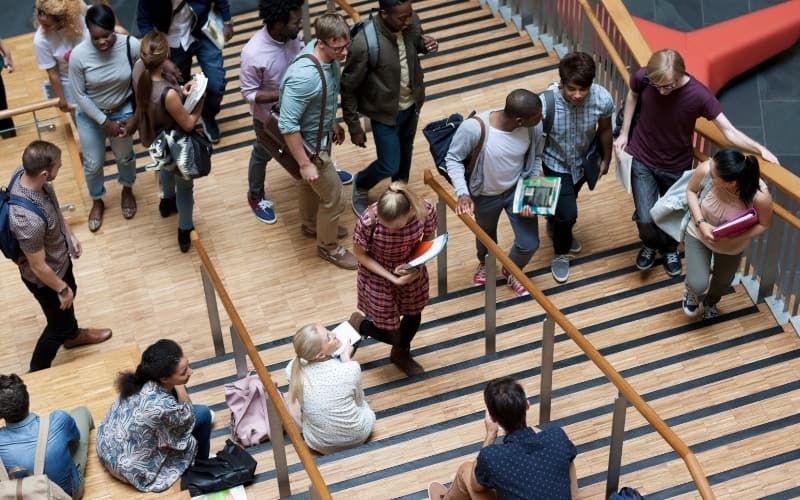 Students gathering on a busy campus staircase during university application season.