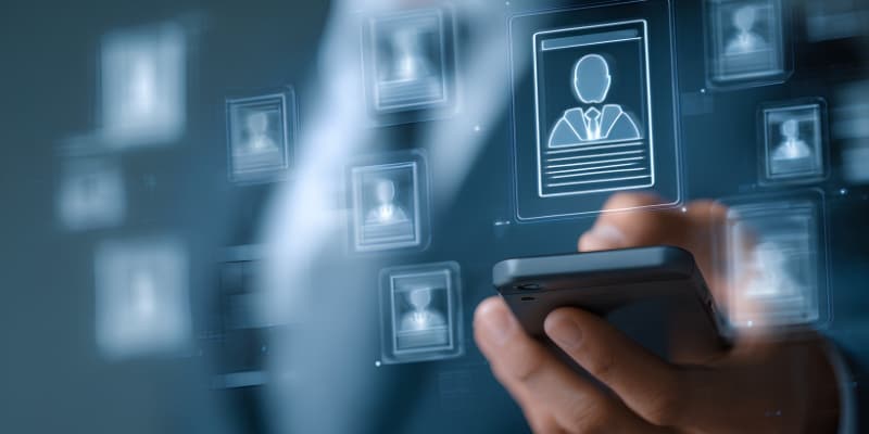 A person using a smartphone with digital profile icons displayed, representing unified customer data.