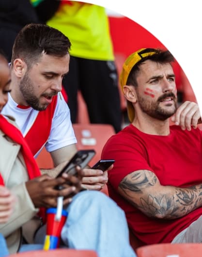 Fans at a stadium using mobile devices, highlighting the importance of digital communication during the 2026 FIFA World Cup for government leaders.