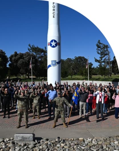 The 30th Force Support Squadron pose for a group photo in front of Missile V, a Minuteman III missile static display at Vandenberg Space Force Base, Calif., May 7, 2024. PHOTO BY: Airman 1st Class Olga Houtsma – This photograph is considered public domain.