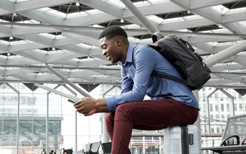 Person checking phone while waiting at a train station