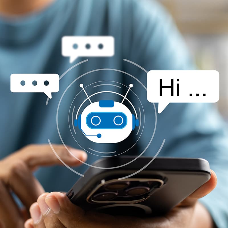 A person in a blue shirt holds a smartphone with a chatbot icon and speech bubbles saying 