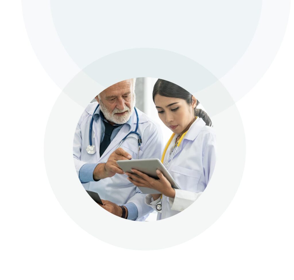 Senior male doctor using tablet while discussing with another doctor at the hospital.