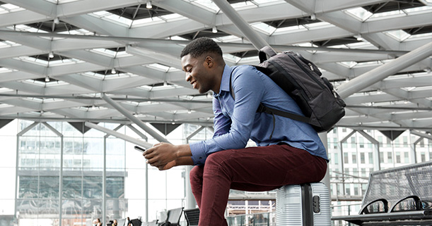 Person checking phone while waiting at a train station