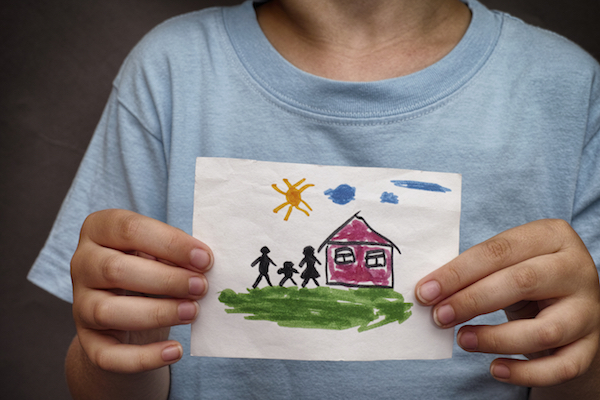 Florida Department of Children and Families image Child holds a drawn house with family