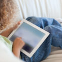 Webinar Recap: Public Sector Transparency Through Video image Back view young boy using a tablet computer
