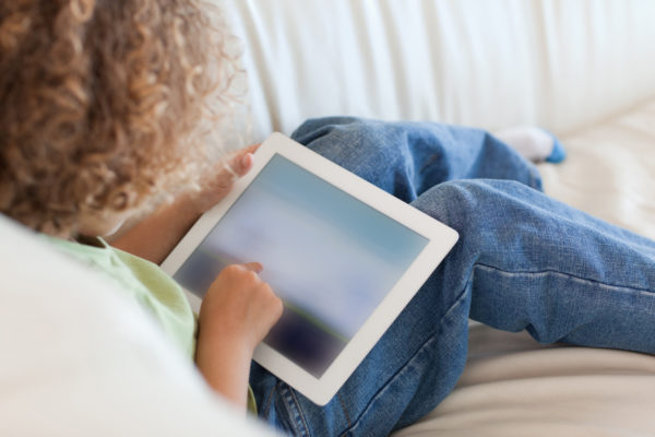 Webinar Recap: Public Sector Transparency Through Video image Back view young boy using a tablet computer