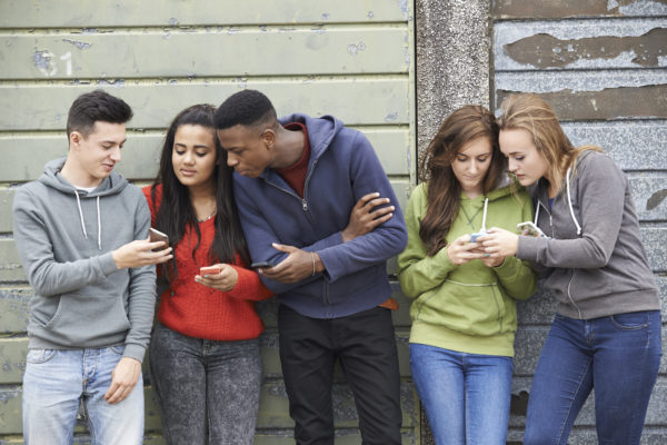 University of Michigan Department of Family Medicine image Group Of Teenagers Sharing Text Message On Mobile Phones