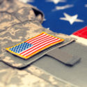 How you can help a returning veteran image USA flag with army uniform over it - studio shot. Filtered image: cross processed vintage effect.
