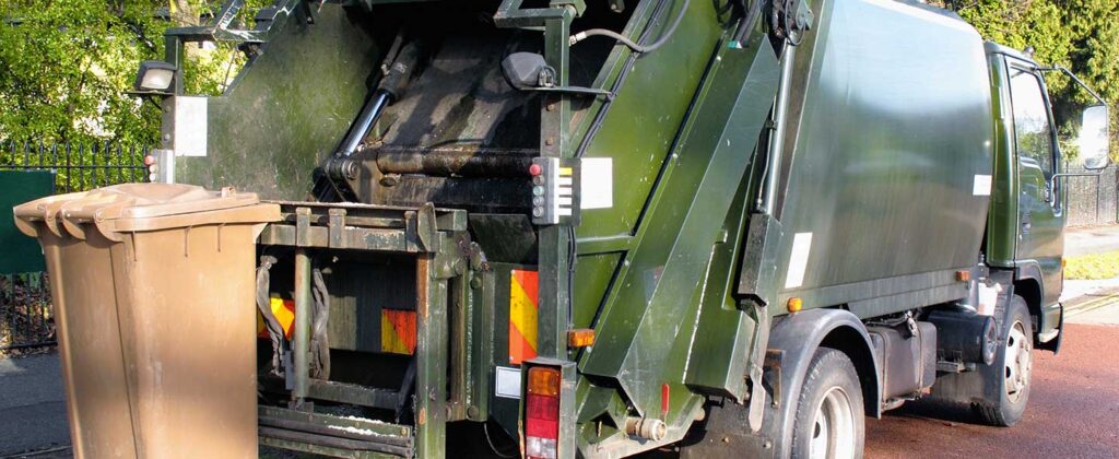 Garbage truck picking up trash on a quiet street