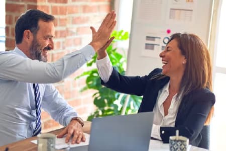 Two happy colleagues high-fiving each other