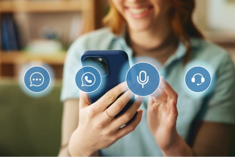 Person using a smartphone displaying chat, voice, and support icons, representing accessible communication across mobile, messaging, and voice channels.