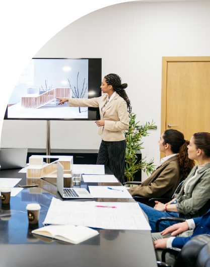 Team collaborating at a meeting, presenting architectural models and plans for a real estate development project