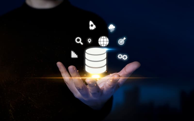 A person holding a glowing digital data icon surrounded by analytics and governance symbols.