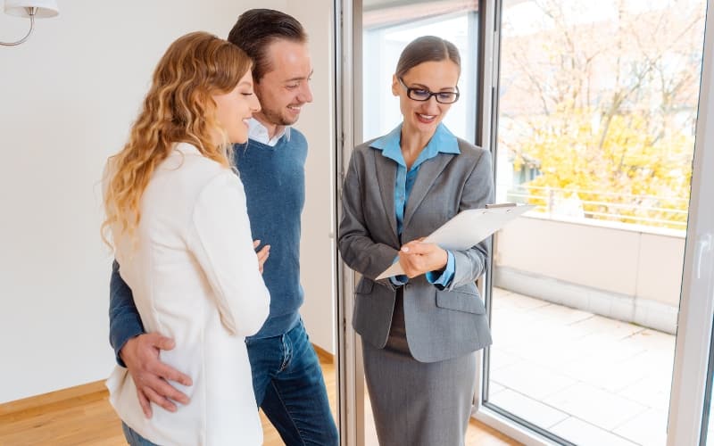Landlord engaging a couple with a personalized property tour, highlighting trust and tailored service.