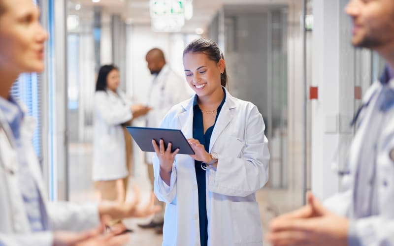 Healthcare professionals collaborate in a hospital corridor, reflecting coordinated NHS communications during ICB reform.
