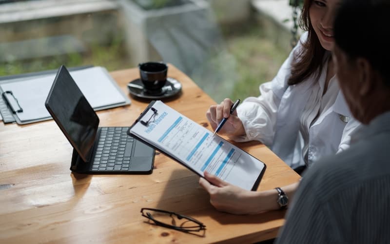 Healthcare professional reviewing Medicaid enrollment forms alongside a digital device, illustrating the shift to digital-first engagement.