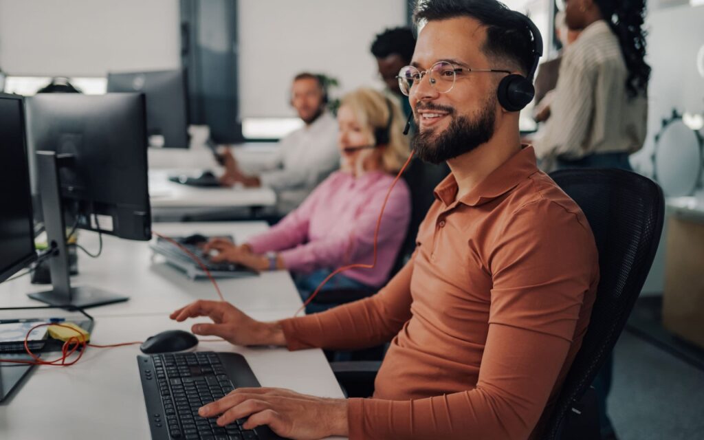 Customer service agents using AI tools to manage 311 calls in a modern office.