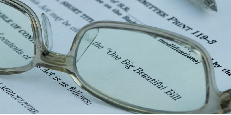 Eyeglasses resting on a document titled 'One Big Beautiful Bill.'