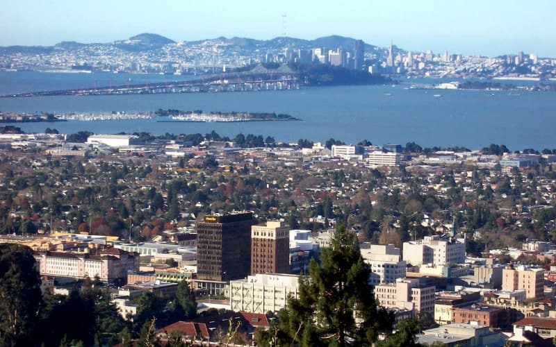 Aerial view of Berkeley with the San Francisco Bay and city skyline in the background.