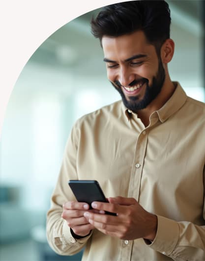 Hombre sonriendo mientras mira su celular