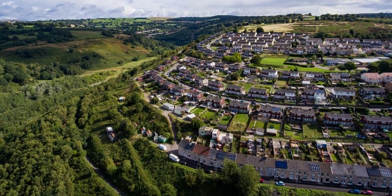 An aerial view of housing in a lush, green, countryside.