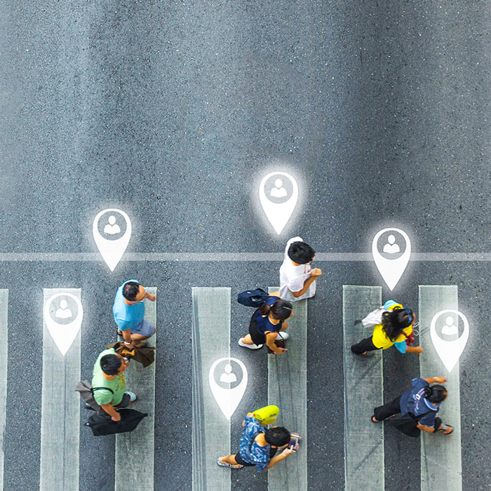 people crossing street looking at phones and sharing their location.