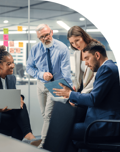 Diverse Team of Managers Use Laptop and Tablet Computers at a Meeting