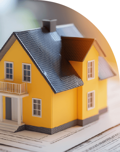 Miniature yellow house on paperwork representing real estate transactions.
